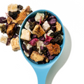 Guava Colada loose leaf tea in a blue spoon with fruit pieces