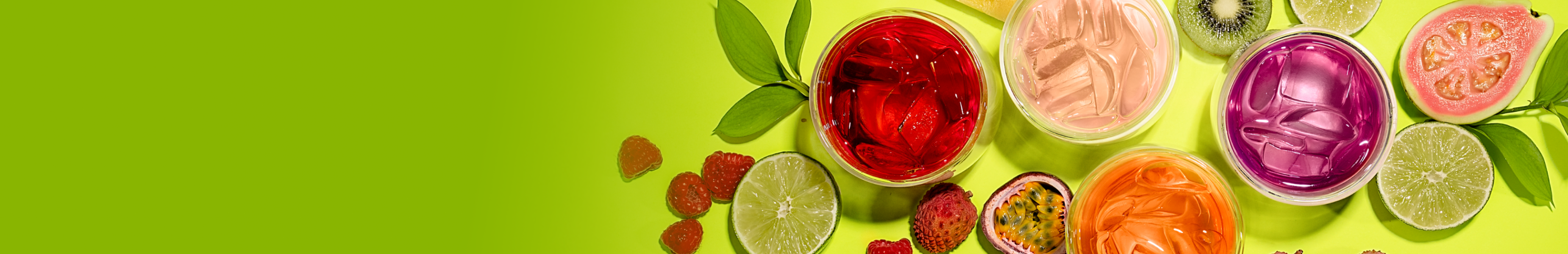 Fruity colorful iced teas surrounded by cut fruit 