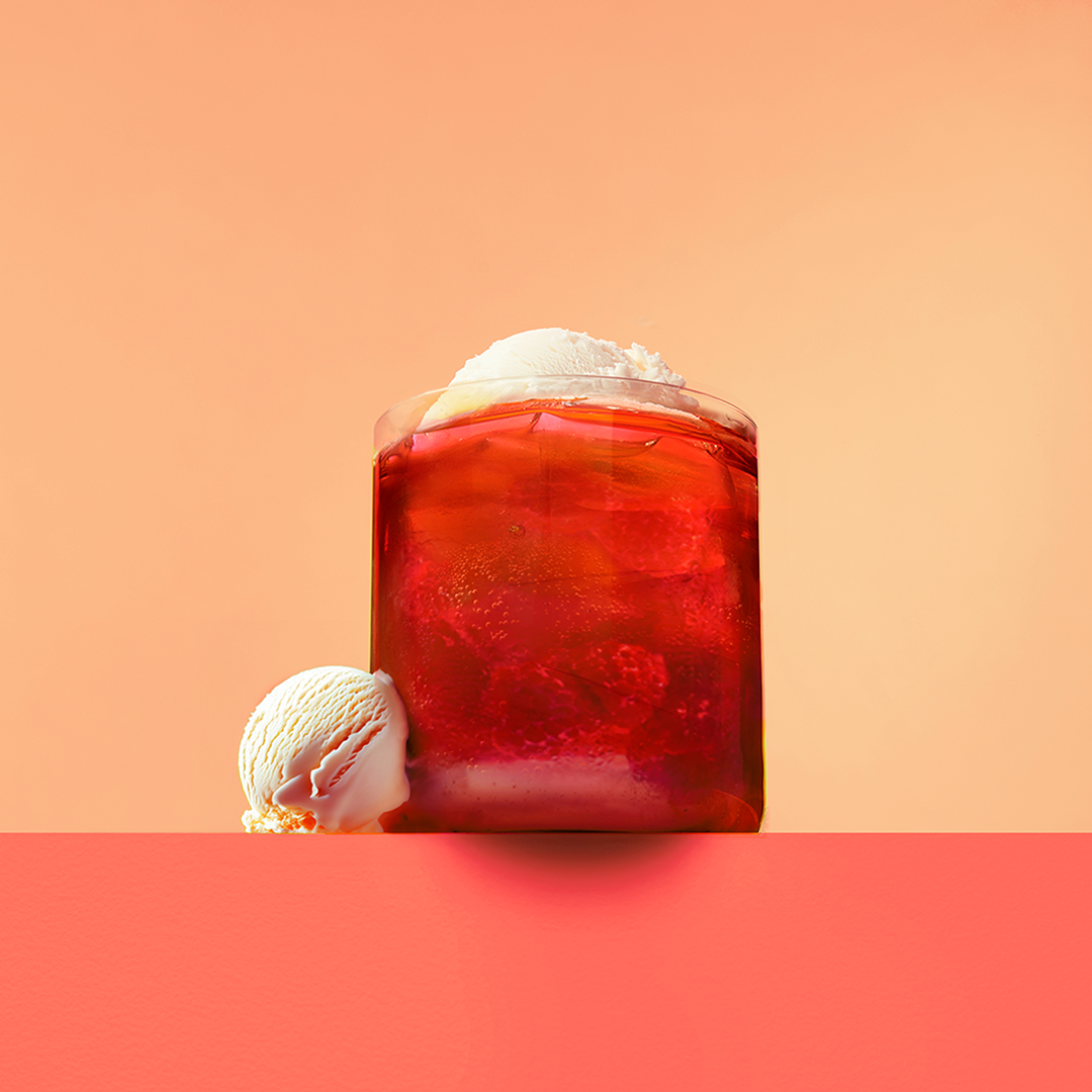 red raspberry tea in a clear glass with vanilla ice cream
