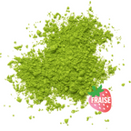 Poudre de matcha verte saveur fraise sur fond blanc.