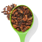 Organic Orange Spice loose leaf tea in a green spoon with spices